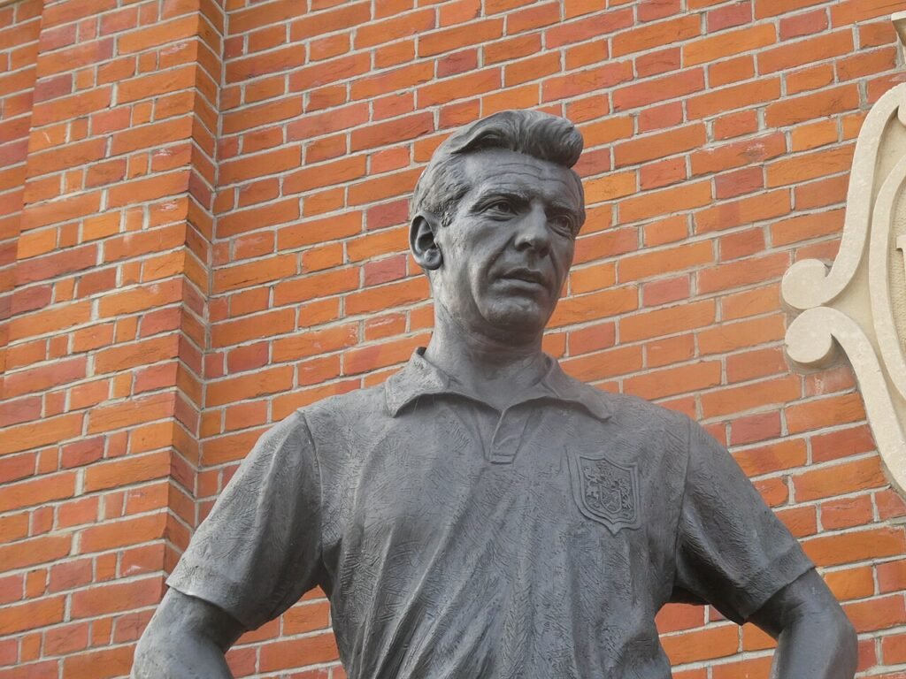 Johnny Haynes-statuen utenfor Craven Cottage, 24. januar 2026. Timmy96 / Wikimedia Commons, CC0 1.0 (https://creativecommons.org/publicdomain/zero/1.0/). Møtested for turer; ved kamp gjelder billettens inngang. Nedskalert Wikimedia-forhåndsvisning. · Craven Cottage